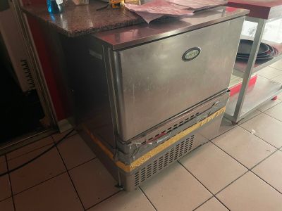 une image d'une cuisine avec une cuisinière et un réfrigérateur