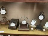 de nombreuses horloges différentes posées sur une étagère dans une pièce