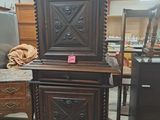 a tall wooden cabinet with a mirror on top of it