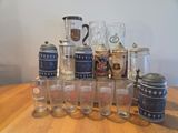 a lot of beer glasses and a pitcher on a table