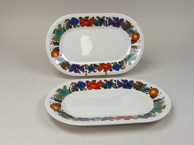 two plates with floral designs on them are sitting on a table