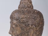 statue of a head of a buddha on a white base