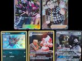 Plusieurs cartes Pokémon sont disposées sur une surface noire