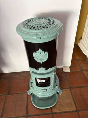 a blue and black stove sitting on a tiled floor