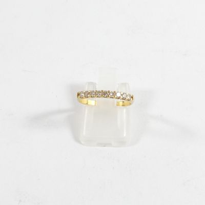 gros plan d'une bague en or avec des diamants sur une surface blanche