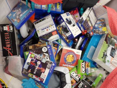 un tas d'objets divers liés aux jeux vidéo dans un bac