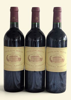 three bottles of wine are lined up on a white surface