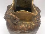 un vase en bronze orné d'une poignée en forme de dragon