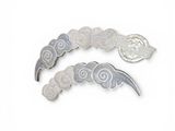 two pieces of silver and white brooches on a white surface