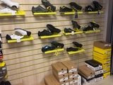 many pairs of shoes on the shelves in the store