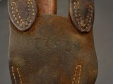 a brown leather bag with two ears on a wooden stick