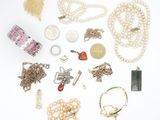 many different types of necklaces and bracelets laid out on a white surface