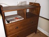 a wooden dresser with a book on top of it