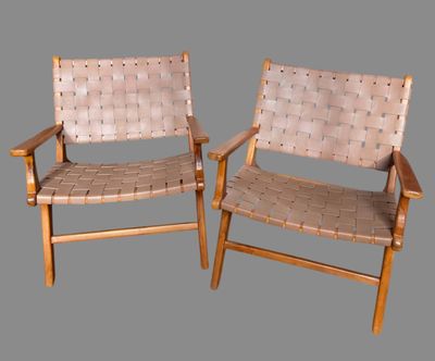 pair of woven leather lounge chairs with wooden frame and arms