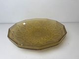 yellow glass platter with a decorative design on it on a white surface