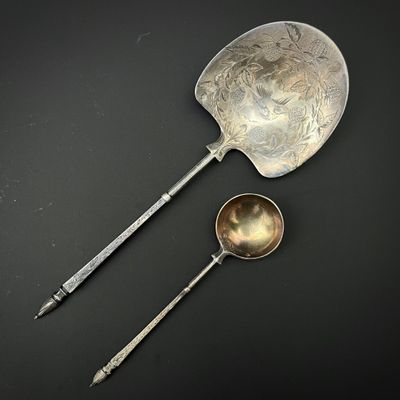 deux cuillères et un repose-cuillère posés sur une surface noire