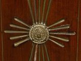 a wooden cabinet with a metal sunburst on it