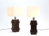 pair of wooden table lamps with white lampshads on top of them