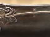 a close up of a silver spoon with a flower design