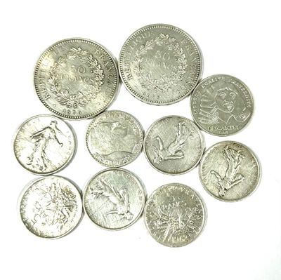 some silver coins sitting on top of each other on a white surface