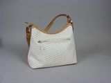 the white purse is sitting on a white surface with a brown handle