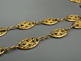 a close up of a gold necklace on a table