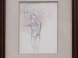 framed drawing of a nude woman standing in front of a brick wall