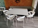 a table and chairs in a room with a clock on the wall