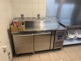 a stainless steel kitchen with a sink and a refrigerator