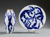 une assiette bleue et blanche et un vase bleu et blanc posé sur un socle