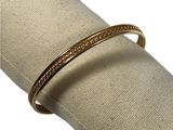 an image of a close up of a gold bracelet on a napkin