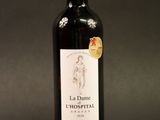 une photo d'une bouteille de vin rouge sur fond noir