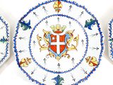 three decorative plates with a coat of arms and a cross on them