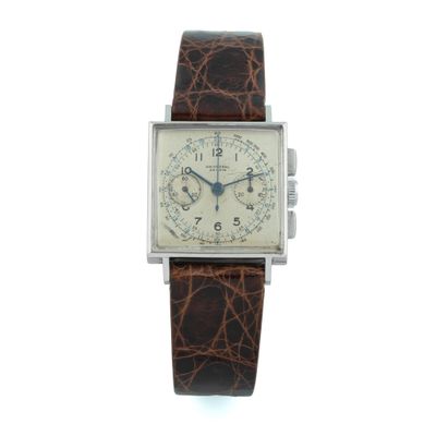 a close up of a watch on a white surface with a brown strap