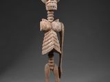 une statue représentant un squelette humain avec une grosse tête et un torse imposant