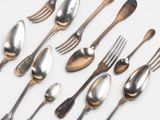 a lot of silver spoons and forks on the table