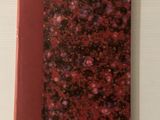 une photo d'un livre à la couverture rouge posé sur une table