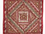 une tapisserie rouge et dorée accrochée à un mur blanc