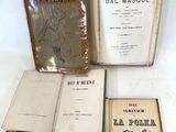 Plusieurs vieux livres sont posés sur une table, dont un certain nombre