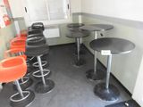 de nombreux tabourets et tables dans une pièce dotée d'une fenêtre