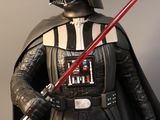 star wars action figure of darth vader holding a red light saber
