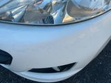 un gros plan sur le phare d'une voiture dans un parking
