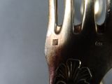 a close up of a silver fork with a flower on it