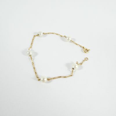 a gold chain bracelet with pearls and pearls on a white background