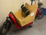 un vélo rouge et jaune auquel est attelée une remorque