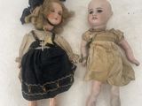 two dolls laying next to each other on a white surface