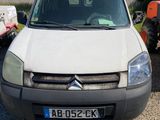 La camionnette blanche est garée à côté d'un tracteur dans l'allée.