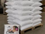 une pile d'oreillers posée sur une palette dans un entrepôt