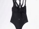 un maillot de bain noir sur fond blanc, avec un fond blanc