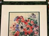trois photos de fleurs encadrées exposées dans un magasin